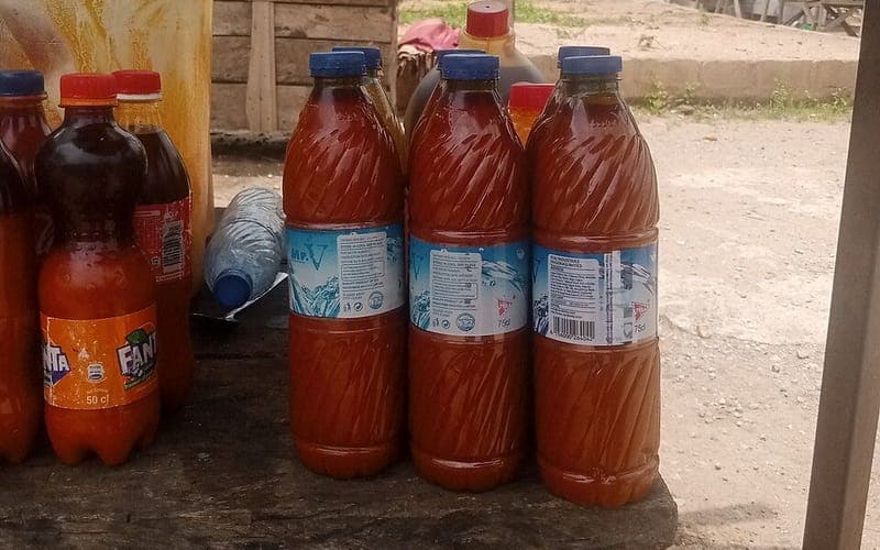 Bouteilles d’huile de palme rouge sur un étal